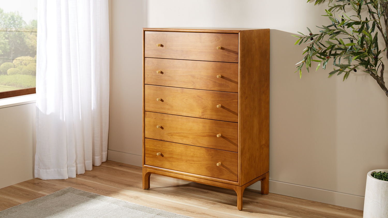 Five-drawer wooden chest with warm finish, brass-look handles and raised legs