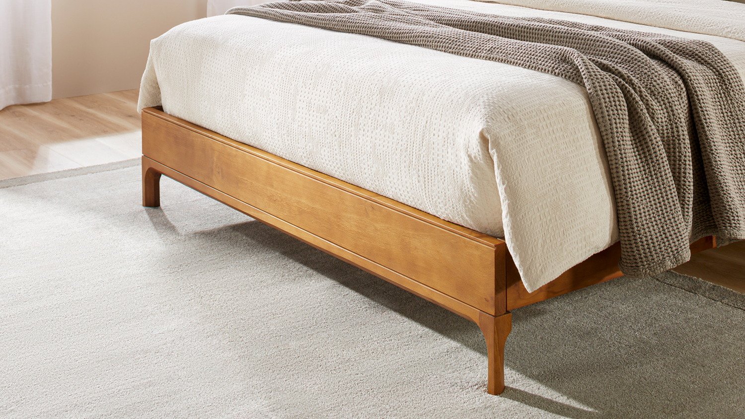 Low-angle view of the bed frame featuring light wood tone