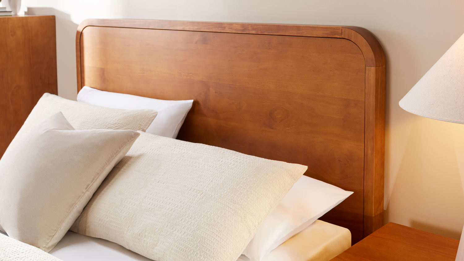 Close-up view of the Harper Headboard featuring a warm timber finish and smooth panel design