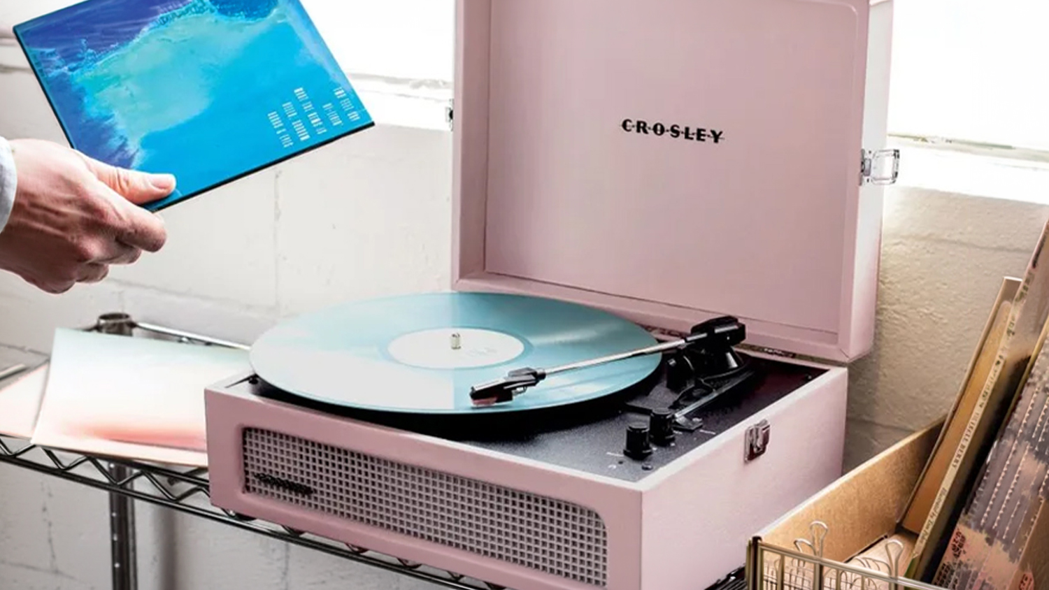 Blush pink vinyl record player with open lid, black platter and front speaker grille