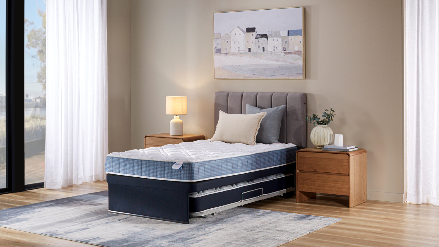 Blue and white Abode Medium King Single Trundle Bed by Tattersfield with a quilted mattress and grey upholstered headboard in a bedroom setting