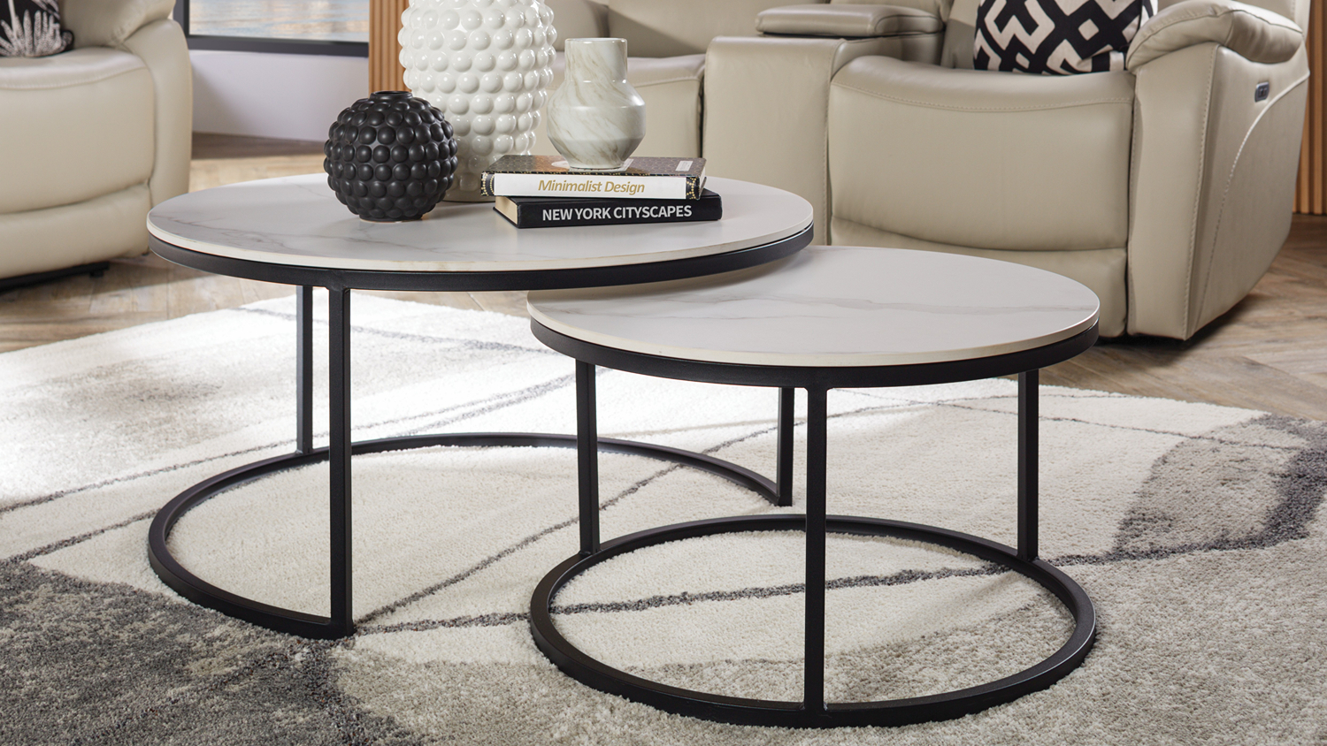Orbit white round nesting coffee tables with black metal frames styled on a grey patterned rug