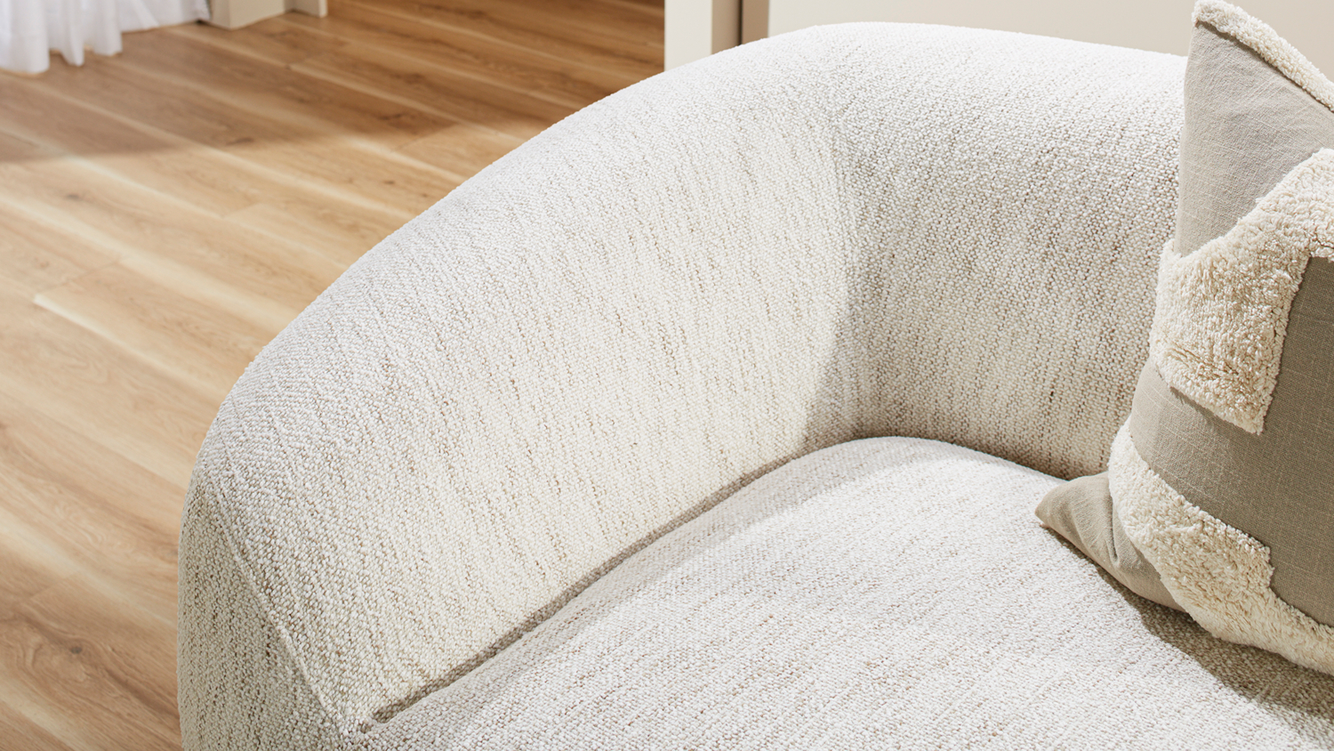 Close-up view of the rounded armrest and plush seat cushion of the Villa Fabric Swivel Chair in Optical