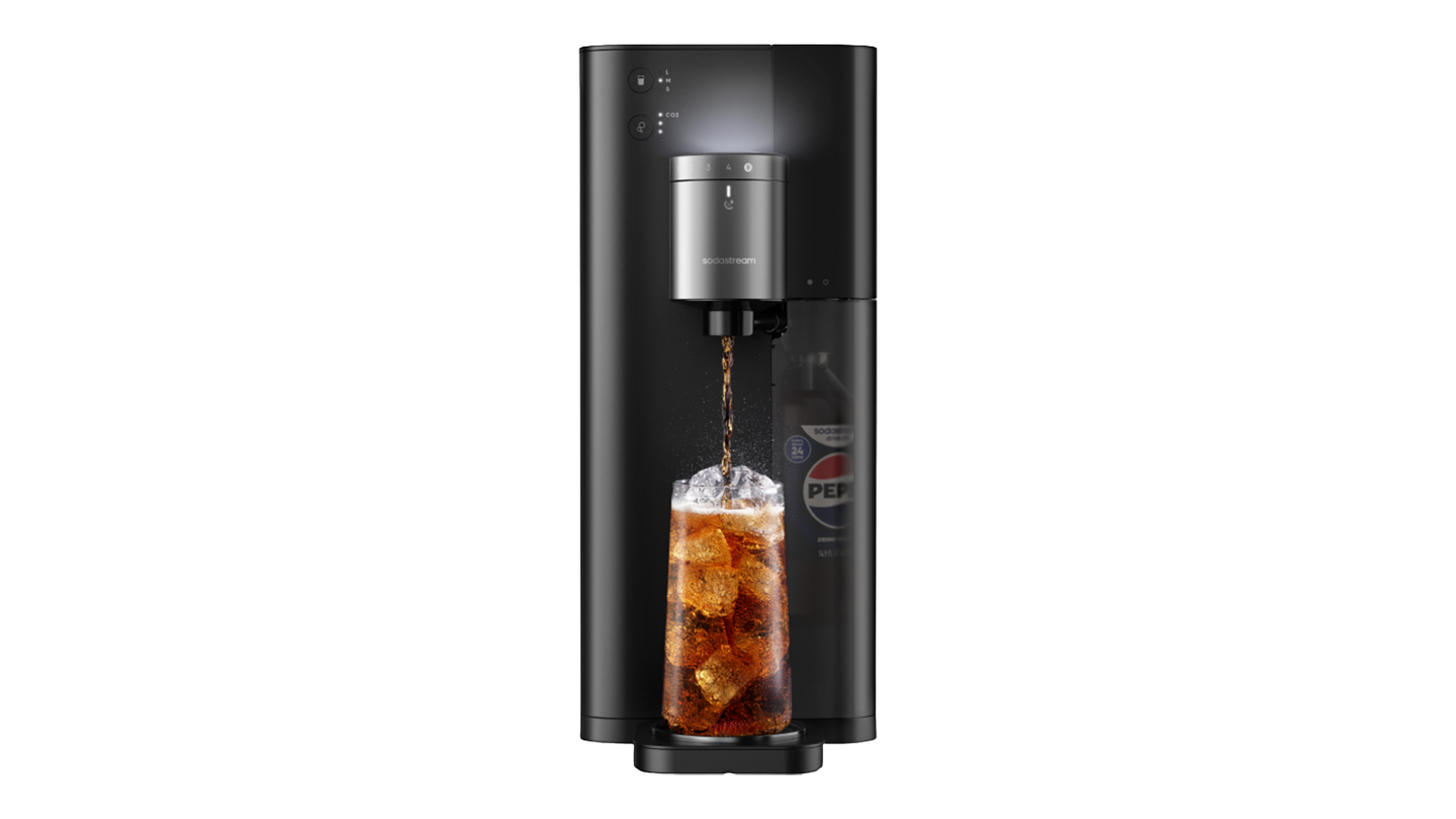 Front view of a black and silver SodaStream Ultimate Sparkling Water Maker pouring cola over ice into a glass with a transparent side panel