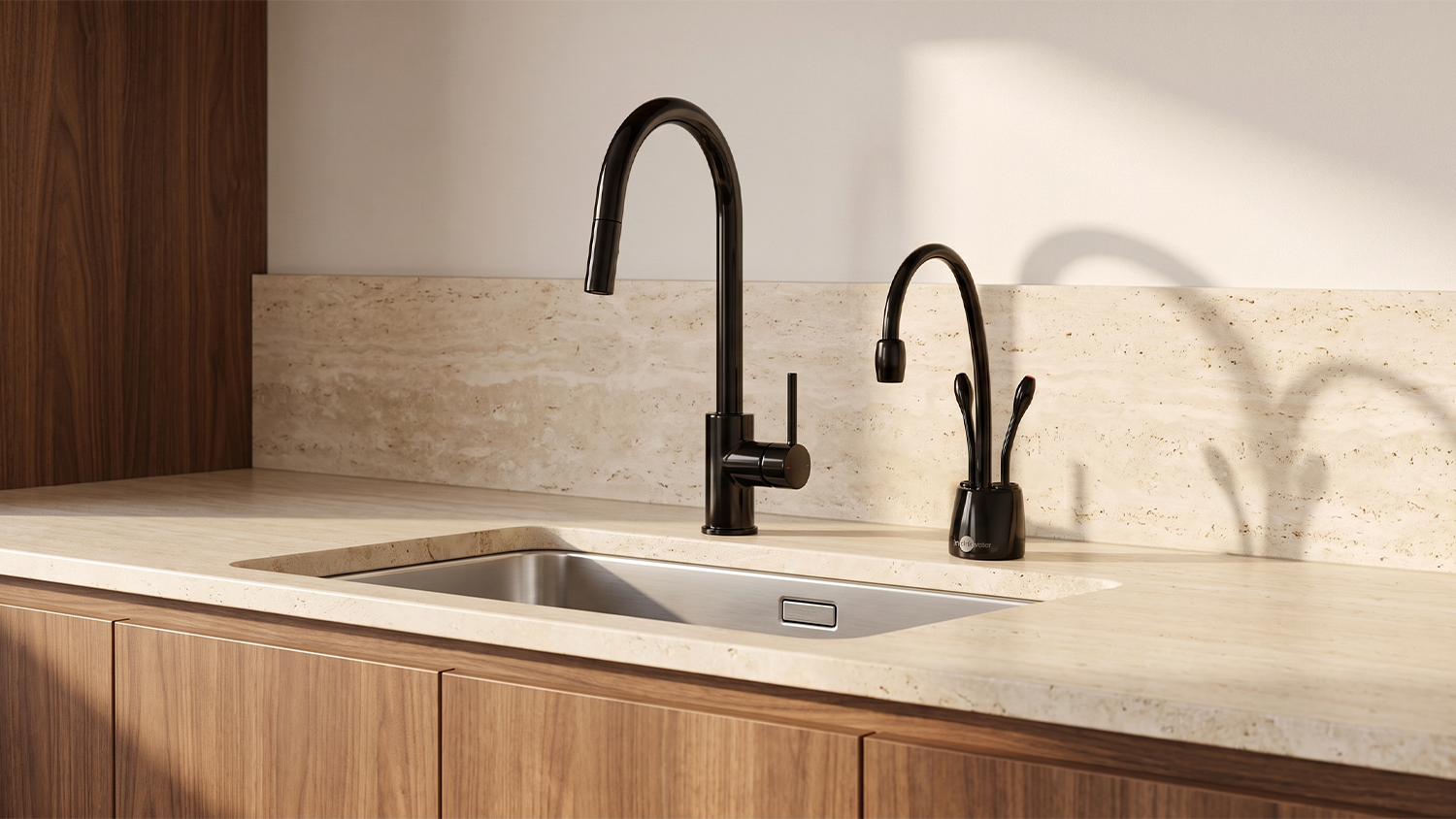 A modern kitchen counter featuring a sleek matte black InSinkErator HotTap Boiling & Cold Filtered Side Tap mounted over a sleek kitchen sink