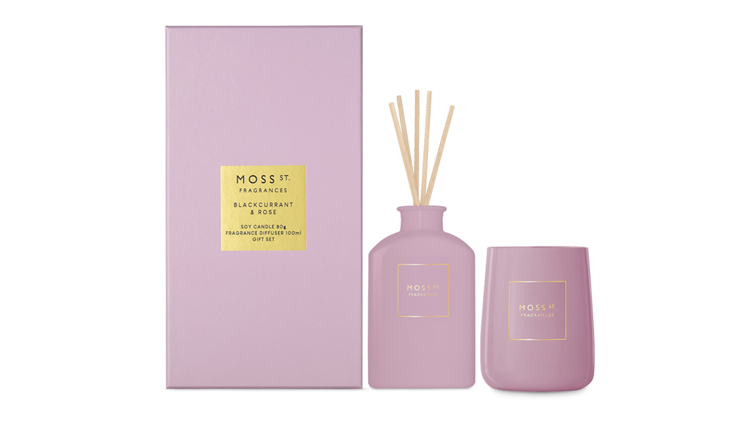 Front view of the Moss St. reed diffuser and candle with gold labels among floating rose petals and blackcurrants